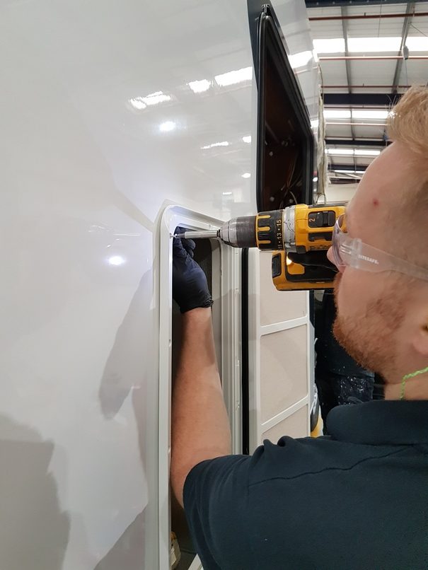 Mechanical fasteners being installed onto a caravan